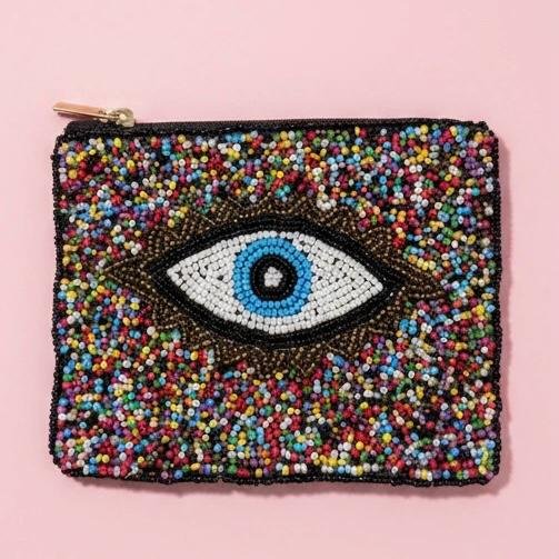 "Occhio Arcobaleno Pouch"  Protection with a Pop of Color. Add vibrant energy and protective symbolism to your everyday carry with the Occhio Arcobaleno beaded pouch. Designed to celebrate color, joy, and tradition, this handcrafted accessory features a beautifully detailed evil eye motif surrounded by a dazzling explosion of multicolored glass beads.  Fully lined with soft interior fabric, and zip closure with gold-toned hardware. Dimensions: 5" x 4" Perfect as a jewelry pouch, or coin purse, this artisanal piece embodies craftsmanship and meaning. Every bead reflects light, symbolizing resilience, clarity, and confidence.