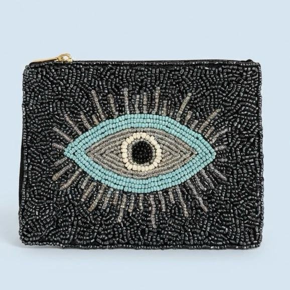 "Occhio Notturno Pouch"  Protection With a Midnight Glow. B old, striking, and infused with meaning, the Occhio Notturno beaded pouch is a modern talisman of style and protection. Hand-embroidered with hundreds of jet-black and metallic beads, it features a radiant turquoise evil eye at the center, symbolizing intuition, grounding, and shielding from negative energy. Fully lined with soft interior fabric, and zip closure with gold-toned hardware. Dimensions: 5" x 4" Perfect as a jewelry pouch, or coin purse, this artisanal piece embodies craftsmanship and meaning. Every bead reflects light, symbolizing resilience, clarity, and confidence.