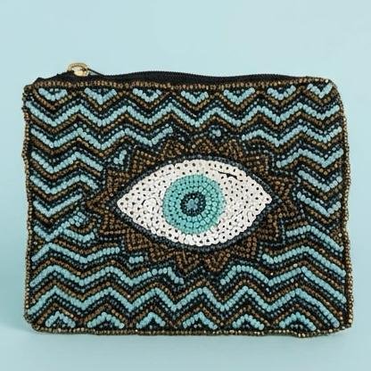 "Occhio di Luce Pouch" Protection in Style. Inspired by the ancient Italian belief in the malocchio—the evil eye—this stunning hand-beaded pouch brings both protection and beauty to your everyday essentials. The Occhio di Luce is handcrafted with meticulous beadwork featuring a radiant turquoise and gold chevron pattern centered by the symbolic evil eye, known to ward off negativity and invite good fortune. Fully lined with soft interior fabric, and zip closure with gold-toned hardware. Dimensions: 5" x 4" Perfect as a jewelry pouch, or coin purse, this artisanal piece embodies craftsmanship and meaning. Every bead reflects light, symbolizing resilience, clarity, and confidence.
