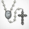 "Cameo Rosary – Mother’s Kiss" A tender devotion, beautifully preserved. The Cameo Rosary – Mother’s Kiss is a timeless, elegant piece crafted for those who cherish faith, love, and the gentle bond between mother and child. Featuring luminous pearl-style beads and an intricately detailed cameo centerpiece, this rosary beautifully portrays Mary cradling the infant Jesus — a symbol of unconditional love, nurturing, and divine protection. The antique-inspired crucifix adds a touch of classic reverence, making this rosary both a meaningful devotional tool and a cherished keepsake. Whether prayed with daily or gifted to someone special, Mother’s Kiss is a heartfelt reminder of comfort, guidance, and grace. Perfect for Mother’s Day, baptisms, confirmations, memorial gifts, or anyone seeking a rosary that celebrates both faith and maternal love.