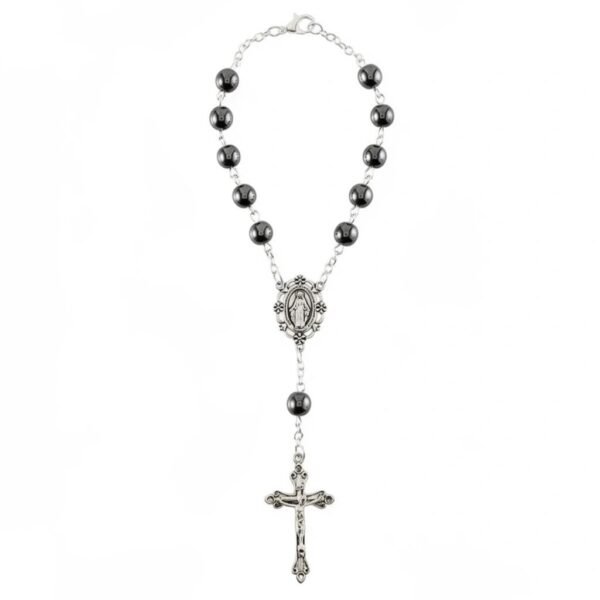 " Madonna della Strada" A blessing for every journey. Bring peace, protection, and spiritual comfort wherever the road leads with the Madonna della Strada Car Rosary. Designed specially for your rearview mirror, this compact rosary features glossy hematite-style beads, a detailed Our Lady centerpiece, and an ornate crucifix. Crafted to be both devotional and durable, it serves as a daily reminder that you are never traveling alone. Whether you’re commuting, carpooling, or making long drives, this piece offers a sense of calm and grace with every mile. A meaningful gift for new drivers, loved ones, or anyone who finds strength in their faith during life’s journeys.