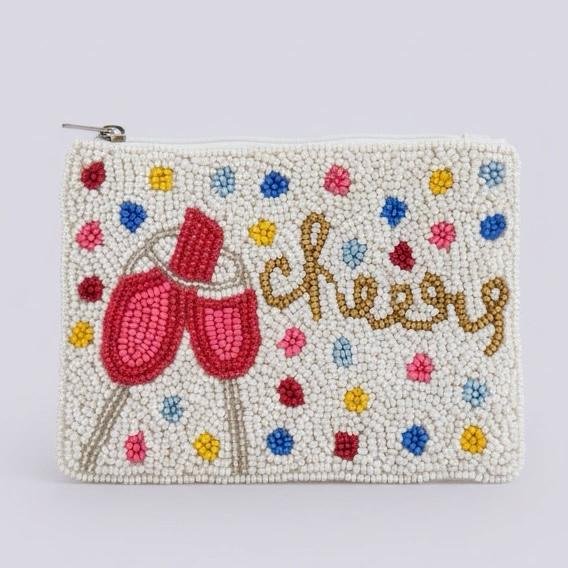"Celebration Cheers Pouch" Pop, fizz, and sparkle. Celebrate life’s little moments with the Celebrations Cheers! Confetti Beaded Pouch. Hand-beaded on a soft ivory base, this playful design features vibrant confetti beads, two shimmering glasses, and a golden “cheers” script that radiates happiness. Compact yet eye-catching, it’s ideal for cards, cash, lip gloss, or small essentials. A perfect pouch for parties, birthdays, holidays, bachelorette bags—or anyone who loves a little sparkle in their day. Fully lined with soft interior fabric, and zip closure with silver-toned hardware. Dimensions: 5" x 4". Perfect as a jewelry pouch, or coin purse, this artisanal piece embodies craftsmanship and meaning. Every bead reflects light, symbolizing resilience, clarity, and confidence.
