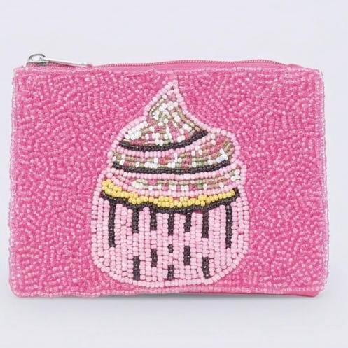 "Dolce Cupcake Pouch" A little sweetness you can carry. Add a touch of joy to your everyday essentials with the Dolce Cupcake Beaded Pouch. Hand-beaded in bright pink with a whimsical cupcake design, this mini pouch brings together sweetness, sparkle, and personality. Ideal for carrying small must-haves — from coins to charms to beauty essentials — it’s a delightful accessory that makes every day feel a little more dolce. Perfect for gifting, stocking stuffers, birthdays, or simply treating yourself to something irresistibly cute. Fully lined with soft interior fabric, and zip closure with silver-toned hardware. Dimensions: 5" x 4" Perfect as a jewelry pouch, or coin purse, this artisanal piece embodies craftsmanship and meaning. Every bead reflects light, symbolizing resilience, clarity, and confidence.